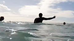 Un surfista levanta la mano para hablar con otro surfista que le recrimina que pegue a un ni&ntilde;o en bodyboard en Snapper Rocks (Australia). 