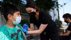 Jair Flores, 12, receives a first dose of the Pfizer Covid-19 vaccine at a mobile vaccination clinic at the Weingart East Los Angeles YMCA on May 14, 2021 in Los Angeles, California.