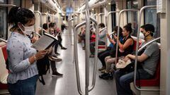 A commuter wears a face mask as a precautionary measure against the spread of the new coronavirus, COVID-19, as she reads a book on the subway in Santiago, on April 8, 2020. - The Chilean government decreed on Monday the mandatory use of face masks on all