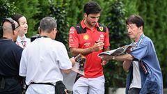 Ferrari's Spanish driver Carlos Sainz Jr (2nd R) signs autographs as he arrives ahead of the third practice session for the Formula One Japanese Grand Prix at the Suzuka circuit, Mie prefecture on September 23, 2023. (Photo by Peter PARKS / AFP)