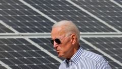 Joe Biden walks past solar panels while touring the Plymouth Area Renewable Energy Initiative in Plymouth, New Hampshire.