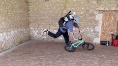 Matthias Dandois montando BMX Flatland con su hijo Minus en la mochila, en el parking de su casa en Francia. 