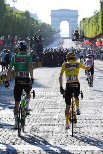 Jumbo-Visma team's Belgian rider Wout Van Aert (L), wearing the sprinter's green jersey and Jumbo-Visma team's Danish rider Jonas Vingegaard, wearing the overall leader's yellow jersey react as they cross the finish line of the 109th edition of the Tour de France.
