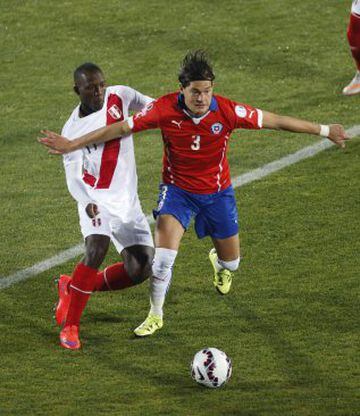 El defensa peruano Luis Advincula (i) pelea por el balón con el defensa chileno Miiko Albornoz durante el partido Chile-Perú, de semifinales de la Copa América de Chile 2015.
