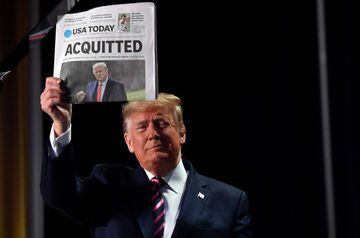 6 Feb 2020 | US President Donald Trump holds up a newspaper that displays a headline "Acquitted" as he arrives to speak at the 68th annual National Prayer Breakfast.