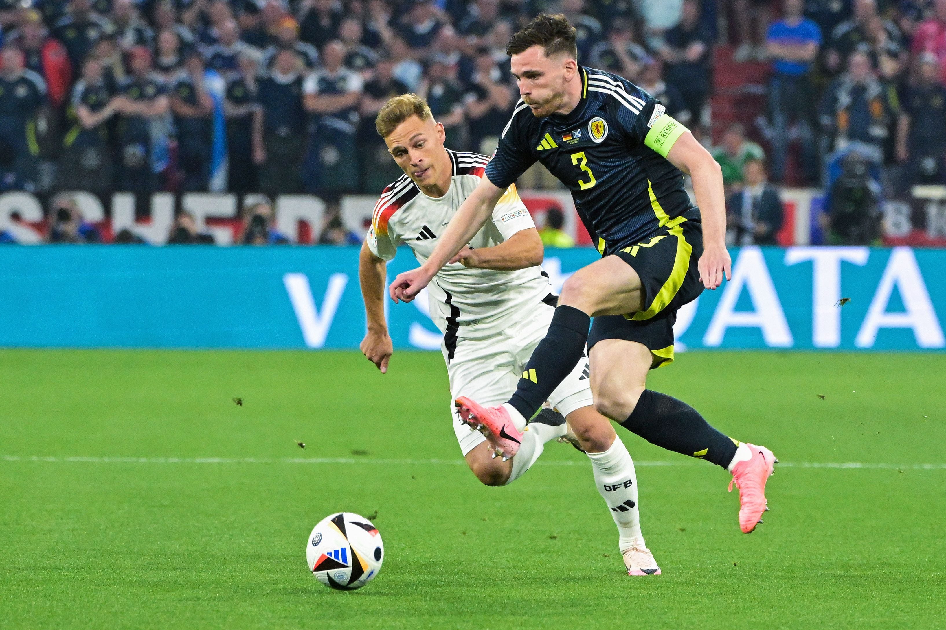 Scotland's defender #03 Andrew Robertson (R) fights for the ball with Germany's defender #06 Joshua Kimmich (L) during the UEFA Euro 2024 Group A football match between Germany and Scotland at the Munich Football Arena in Munich on June 14, 2024. (Photo by DAMIEN MEYER / AFP)