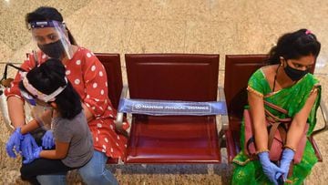 Passengers maintain social distancing while waiting to board their flights at the Chhatrapati Shivaji Maharaj International Airport (CSMIA) after domestic flights resumed, in Mumbai on May 28, 2020. - Domestic air travel resumed in India on May 25 after a