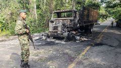 A Colombian soldier stands guard next to a burnt truck in Taraza Municipality, Cauca, Colombia, on March 20, 2023. - Colombian President Gustavo Petro ordered, on March 19, 2023, the resumption of offensive actions against the Clan del Golfo, Colombia's largest drug gang, for attacks on civilians and the security forces, which led him to suspend the ceasefire. (Photo by Eder Narvaez / AFP) (Photo by EDER NARVAEZ/AFP via Getty Images)