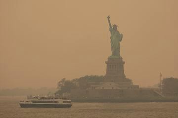 La Estatua de la Libertad, cubierta por un cielo lleno de neblina, es fotografiada desde el ferry de Staten Island. 