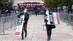 Washington (United States), 27/10/2020.- Poll workers carry signs as Washington DC residents line up to cast their ballots for the 2020 presidential election at the Nationals Park Super Vote Center at Nationals Park in Washington, DC, USA, 27 October 2020