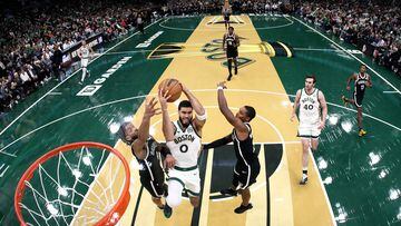 Jayson Tatum #0 of the Boston Celtics takes a shot between Trendon Watford #9 and Lonnie Walker IV #8 of the Brooklyn Nets