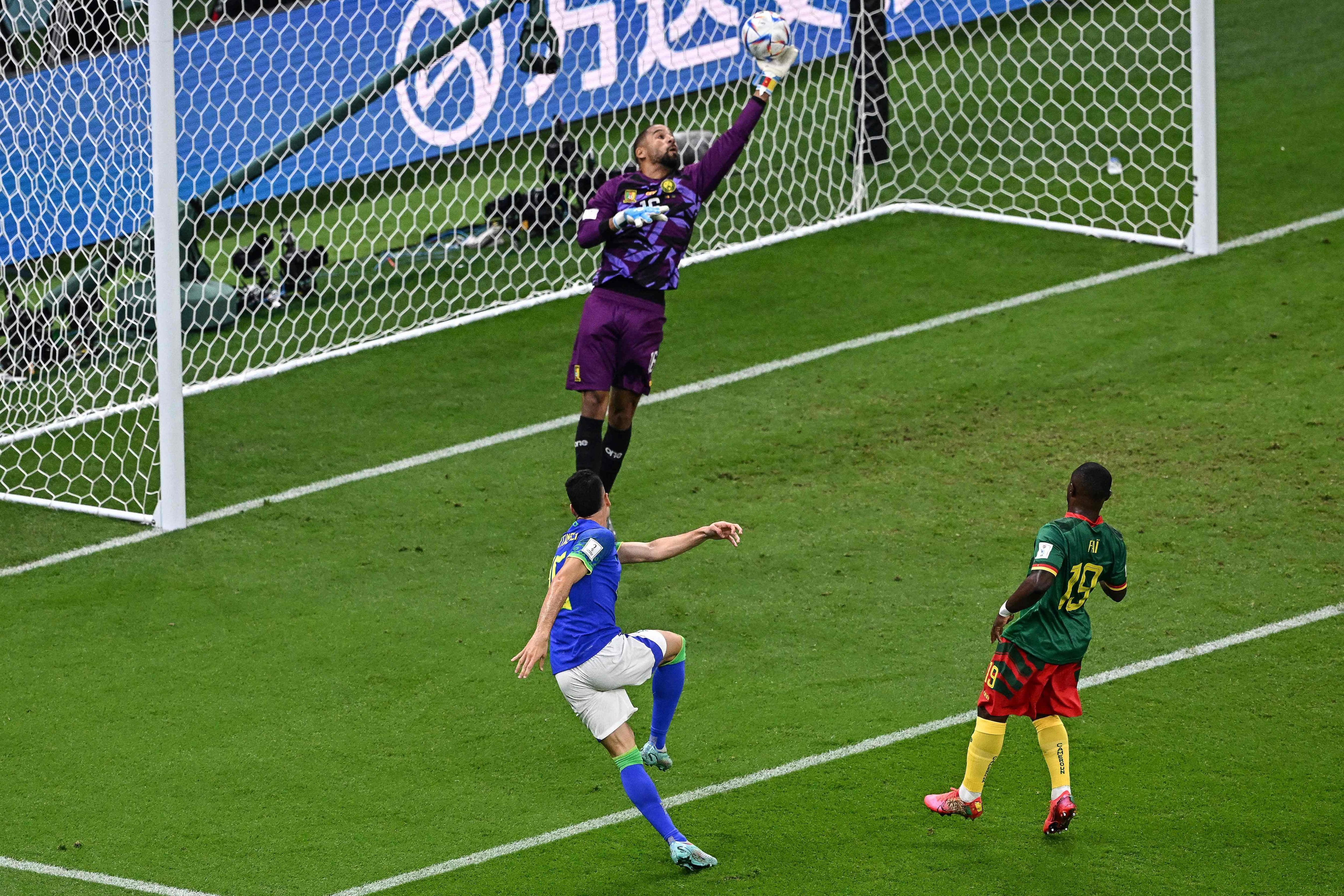 Cameroon's goalkeeper #16 Devis Epassy (rear C) stops the ball shot by Brazil's forward #26 Gabriel Martinelli during the Qatar 2022 World Cup Group G football match between Cameroon and Brazil at the Lusail Stadium in Lusail, north of Doha on December 2, 2022. (Photo by Anne-Christine POUJOULAT / AFP)