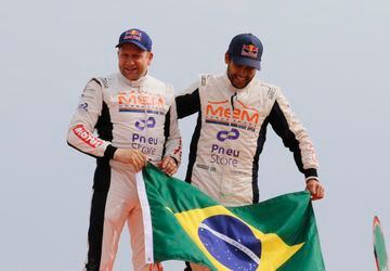El piloto brasileño Lucas Moraes y su copiloto, el alemán  Timo Gottschalk celebran en el podio improvisado encima de los coches, su tercera posición en el Rally Dakar. 