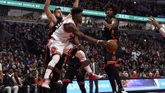Jan 7, 2017; Chicago, IL, USA; Chicago Bulls forward Jimmy Butler (21) passes the ball around Toronto Raptors center Lucas Nogueira (92) during the second half at  the United Center. The Bulls won 123-118 in overtime. Mandatory Credit: David Banks-USA TOD