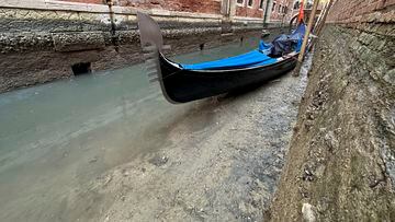 Una góndola en un canal seco durante la marea baja en la ciudad laguna de Venecia, Italia.