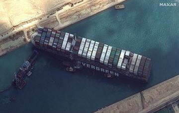 This satellite image released by Maxar Technologies shows tug boats and dredgers attempting to free the MV Ever Given on March 26, 2021, in the Suez Canal.