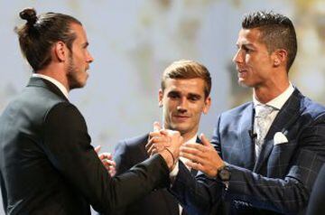 Real Madrid s Cristiano Ronaldo of Portugal (R) reacts with Gareth Bale (L) and Antoine Griezmann (C) after he received the Best Player UEFA 2015/16 Award during the draw ceremony for the 2016/2017 Champions League Cup soccer competition at Monaco's Grima