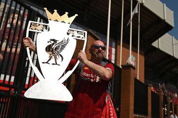 Liverpool fan Paul Davies poses with a cut out of the Premier League trophy outside Anfield after the Reds were crowned English champions for the first time since 1990.