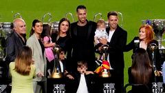 Busquets posa con su familia ante sus títulos con el Barcelona.