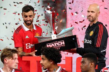 BANGKOK, THAILAND - JULY 12: Bruno Fernandes #8 (L) and manager Erik ten Hag of Manchester United lift the match trophy after defeating Liverpool 4-0 during a preseason friendly match at Rajamangala National Stadium on July 12, 2022 in Bangkok, Thailand. (Photo by Pakawich Damrongkiattisak/Getty Images)