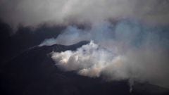 The Cumbre Vieja volcano, pictured from Los Llanos de Aridane, spews ash and smoke on the Canary island of La Palma on December 10, 2021. - The Cumbre Vieja volcano has been erupting since September 19, forcing more than 6,000 people out of their homes as