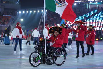 En su silla de ruedas, da la vuelta a todo el estadio mientras ondea orgulloso la bandera tricolor mexicana. 