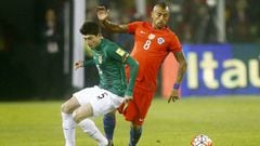 Cabrera disputa un bal&oacute;n con Vidal en el Bolivia-Chile.