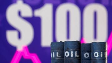 Models of oil barrels are seen in front of a displayed rising stock graph and &quot;$100&quot; in this illustration, February 24, 2022. 