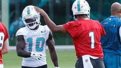 Tua Tagovailoa (right) taps the helmet of Tyreek Hill of the Miami Dolphins between drills during the Miami Dolphins Mandatory Minicamp at the Baptist Health Training Complex.