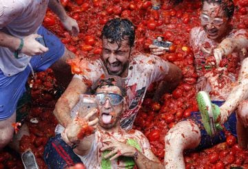 Revelers take pictures as they enjoy throwing tomatoes at each other, during the annual "Tomatina", tomato fight fiesta, in the village of Bunol, 50 kilometers outside Valencia, Spain, Wednesday, Aug. 30, 2017. At the annual "Tomatina" battle, that has become a major tourist attraction, trucks dumped 160 tons of tomatoes for some 20,000 participants, many from abroad, to throw during the hour-long Wednesday morning festivities. (AP Photo/Alberto Saiz)