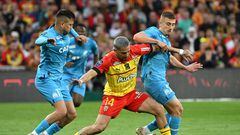Lens' Argentine defender Facundo Medina (C) fights for the ball with Marseille's Turkish forward Cengiz Under (L) and Marseille's French midfielder Valentin Rongier (R) during the French L1 football match between RC Lens and Olympique de Marseille (OM) at Stade Bollaert-Delelis in Lens, northern France on May 6, 2023. (Photo by DENIS CHARLET / AFP)