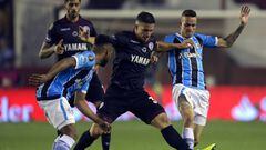 Argentina&#039;s Lanus midfielder Ivan Marcone (C) vies for the ball with Brazil&#039;s Gremio forward Luan (R) and forward Fernandinho during their Copa Libertadores 2017 final football match at Lanus stadium in Lanus, Buenos Aires, Argentina, on Novembe