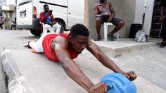 A member of Sixty Honies Fitness Centre, engages in physical exercise along the road to maintain wellness in the face of lockdown as part of measures to prevent the spread of COVID-19 coronavirus in Lagos, on April 12, 2020. (Photo by PIUS UTOMI EKPEI / A