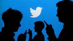 FILE PHOTO: FILE PHOTO: People holding mobile phones are silhouetted against a backdrop projected with the Twitter logo in this illustration picture taken September 27, 2013. REUTERS/Kacper Pempel/Illustration/File Photo/File Photo