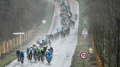 The pack rides in a heavy rain as they take the start of the 148,5km first stage of the 75th edition of the Paris-Nice cycling race, in and around Bois d&#039;Arcy, near Paris on March 5, 2017. / AFP PHOTO / Philippe LOPEZ