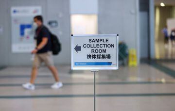 A sign is seen as a man walks to the PCR sample collection room at the main press center ahead of the Tokyo 2020 Olympic Games that were postponed to 2021 due to the coronavirus disease (COVID-19) pandemic, in Tokyo, Japan, July 22, 2021. REUTERS/Siphiwe 