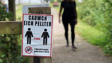 PENARTH, WALES - MAY 20: A social distancing sign written in the Welsh language is seen on a coastal path on May 20, 2020 in Penarth, Wales. The British government has started easing the lockdown it imposed two months ago to curb the spread of Covid-19, a