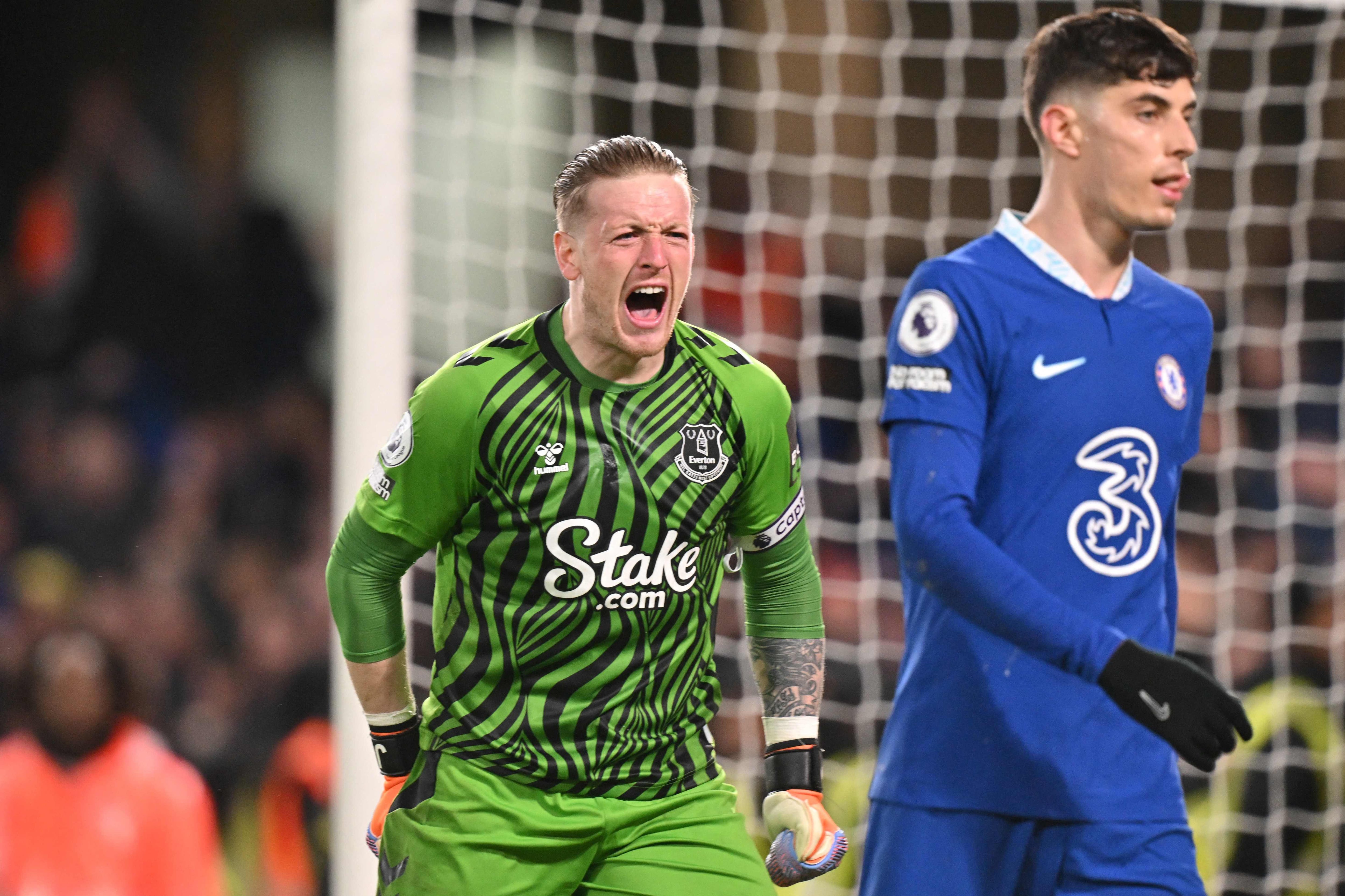 Everton's English goalkeeper Jordan Pickford (L) celebrates behind Chelsea's German midfielder Kai Havertz at the end of the English Premier League football match between Chelsea and Everton at Stamford Bridge in London on March 18, 2023. - Chelsea and Everton equalised 2 - 2. (Photo by Glyn KIRK / AFP) / RESTRICTED TO EDITORIAL USE. No use with unauthorized audio, video, data, fixture lists, club/league logos or 'live' services. Online in-match use limited to 120 images. An additional 40 images may be used in extra time. No video emulation. Social media in-match use limited to 120 images. An additional 40 images may be used in extra time. No use in betting publications, games or single club/league/player publications. / 