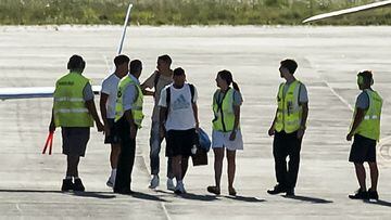 Argentina's Lionel Messi (C front) walks as Argentina's Angel Di Maria (C back) says goodbye to Paulo Dybala --who continues his trip to his hometown Cordoba-- on arrival at the Islas Malvinas international airport to board a helicopter heading to their respective homes, in Rosario, Santa Fe province, Argentina, on December 20, 2022. - Millions of jubilant fans turned out in Buenos Aires to welcome home Argentina's World Cup winners led by Lionel Messi, but most were left disappointed when an open-top bus parade had to be abandoned due to the massive crowds, in favor of a hastily organized helicopter tour. (Photo by AFP)