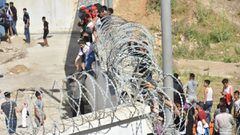 Fnideq (Morocco), 18/05/2021.- Migrants climb the fence in the northern town of Fnideq in an attempt to cross the border from Morocco to the Spanish enclave of Ceuta, in North Africa 18 May 2021. In little over 24 hours a total of almost 8,000 people ente