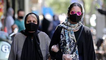 Iranian women wearing protective masks due to the COVID-19 pandemic, walk along a street in the capital Tehran on July 1, 2020. (Photo by ATTA KENARE / AFP)
