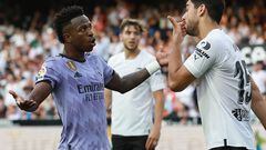 Real Madrid's Brazilian forward Vinicius Junior (L) talks to Valencia's Turkish defender Cenk Ozkacar as he reacts to being insulted from the stands during the Spanish league football match between Valencia CF and Real Madrid CF at the Mestalla stadium in Valencia on May 21, 2023. (Photo by JOSE JORDAN / AFP)