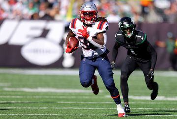 EAST RUTHERFORD, NEW JERSEY - OCTOBER 30: Rhamondre Stevenson #38 of the New England Patriots runs with the ball as Sauce Gardner #1 of the New York Jets defends during the first half at MetLife Stadium on October 30, 2022 in East Rutherford, New Jersey.   Mike Stobe/Getty Images/AFP