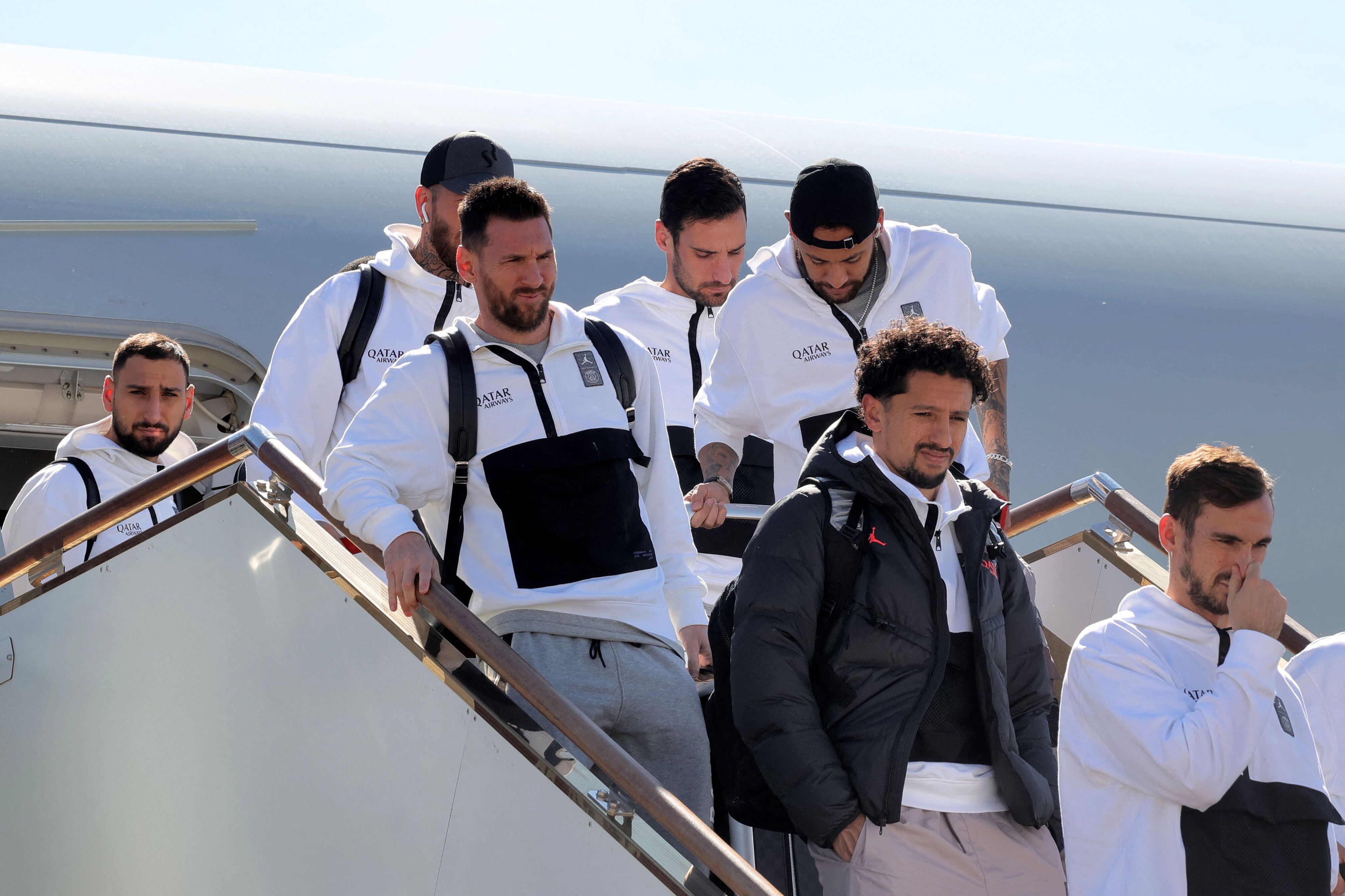 Paris Saint-Germain's Lionel Messi (L), Neymar (R) and other players of the PSG team arrive at an airport in the Saudi capital Riyadh, on January 19, 2023, ahead of a friendly football match as part of the Riyadh Season Cup, against a select side made up of players from Cristiano Ronaldo's new club Al Nassr and their Saudi rivals Al Hilal. - Besides Messi, PSG stars expected to play include France striker Kylian Mbappe and Achraf Hakimi, who last year in Qatar helped make Morocco the first Arab and African team to reach the World Cup semi-finals. The Saudi select team includes Salem Al-Dawsari, who scored the winning goal in the Green Falcons' shock defeat of Argentina in the World Cup's group stage. (Photo by Fayez Nureldine / AFP)