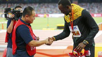 El cámara de televisión que se llevó en su 'Segway' por delante a Usain Bolt en la vuelta de honor de la final de 200m y el propio jamaicano se saludan tras el incidente.