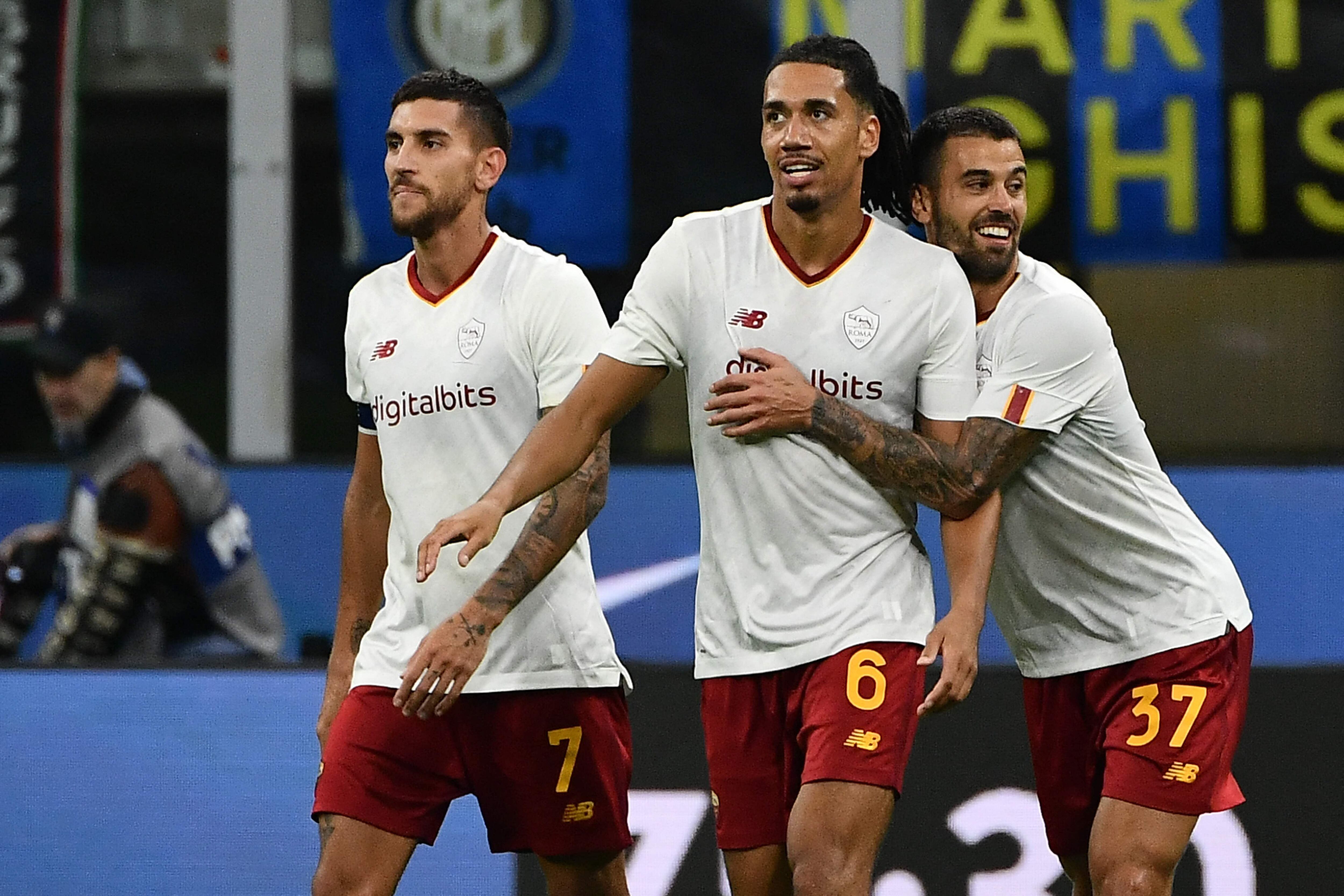 AS Roma's British defender Chris Smalling (C) celebrates with AS Roma's Italian midfielder Lorenzo Pellegrini (L) and AS Roma's Italian defender Leonardo Spinazzola after scoring during the Italian Serie A football match between Inter and AS Roma on October 1, 2022 at the Giuseppe-Meazza (San Siro) stadium in Milan. (Photo by Isabella BONOTTO / AFP)