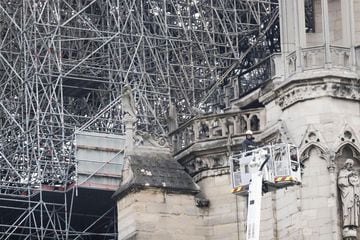Un bombero trabaja en un elevador junto al andamiaje que cubre parte de la catedral de Notre Dame