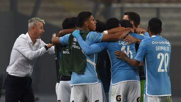 Sporting Cristal's Brazilian coach Tiago Nunes (L) gives instructions to players as they celebrate after teammate Jhilmar Lora (covered) scored his team's first goal during the Copa Libertadores group stage first leg football match between Peru's Sporting Cristal and Bolivia's The Strongest, at the National stadium in Lima, on May 2, 2023. (Photo by CRIS BOURONCLE / AFP)