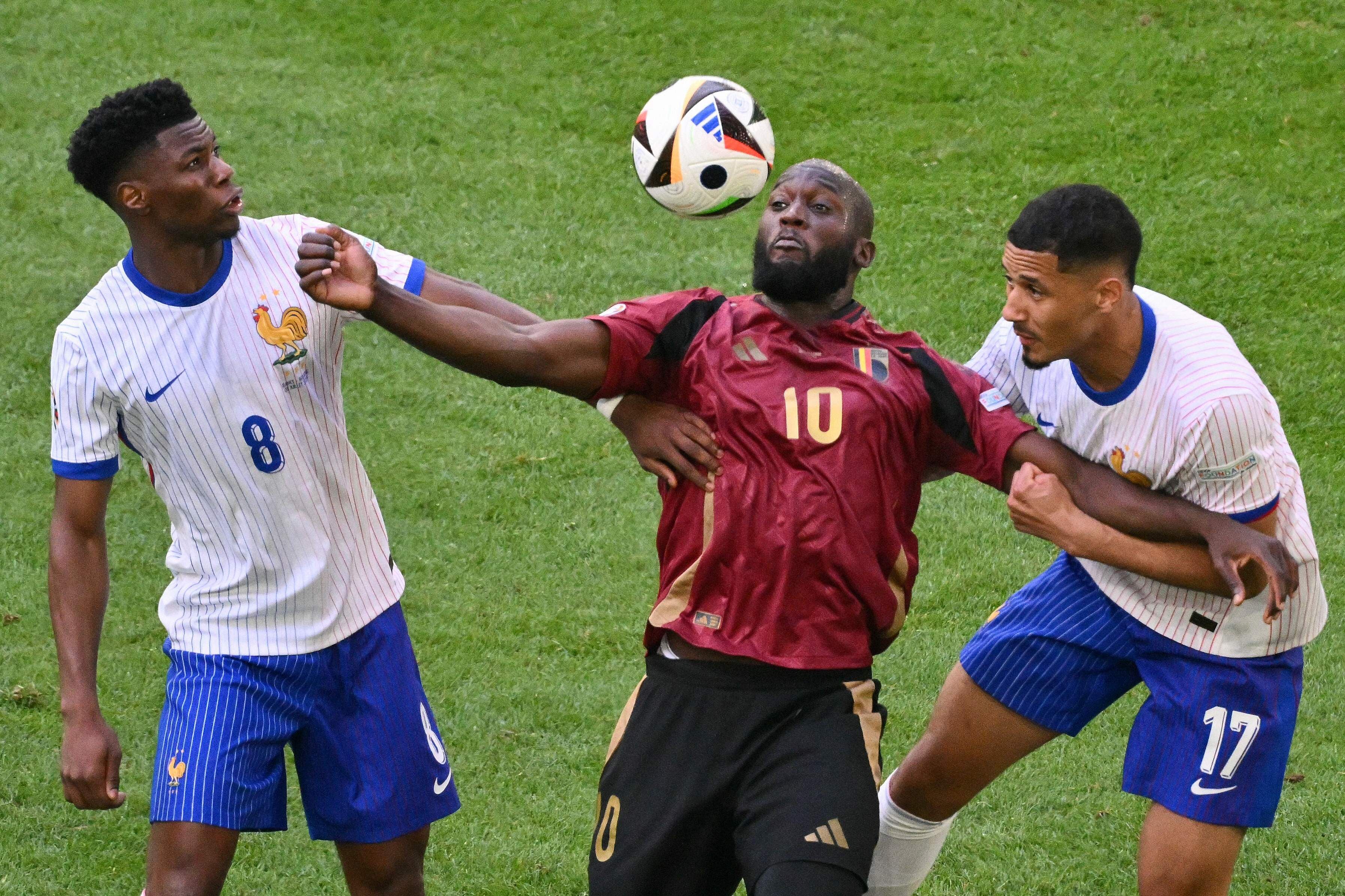 Aurelien Tchouameni, Belgium's forward #10 Romelu Lukaku and France's defender #17 William Saliba fight for the ball during the UEFA Euro 2024 round of 16 football match between France and Belgium at the Duesseldorf Arena in Duesseldorf on July 1, 2024. (Photo by Alberto PIZZOLI / AFP)