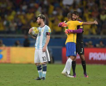 Argentina's Lionel Messi (L) shows his dejection as Brazil's Miranda (C) and goalkeeper Alisson celebrate their 3-0 victory at the end of their 2018 FIFA World Cup qualifier football match in Belo Horizonte, Brazil, on November 10, 2016. / AFP PHOTO